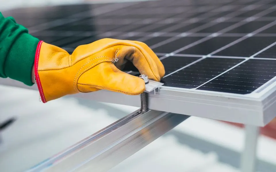 A clamp being fitted to a solar panel frame.