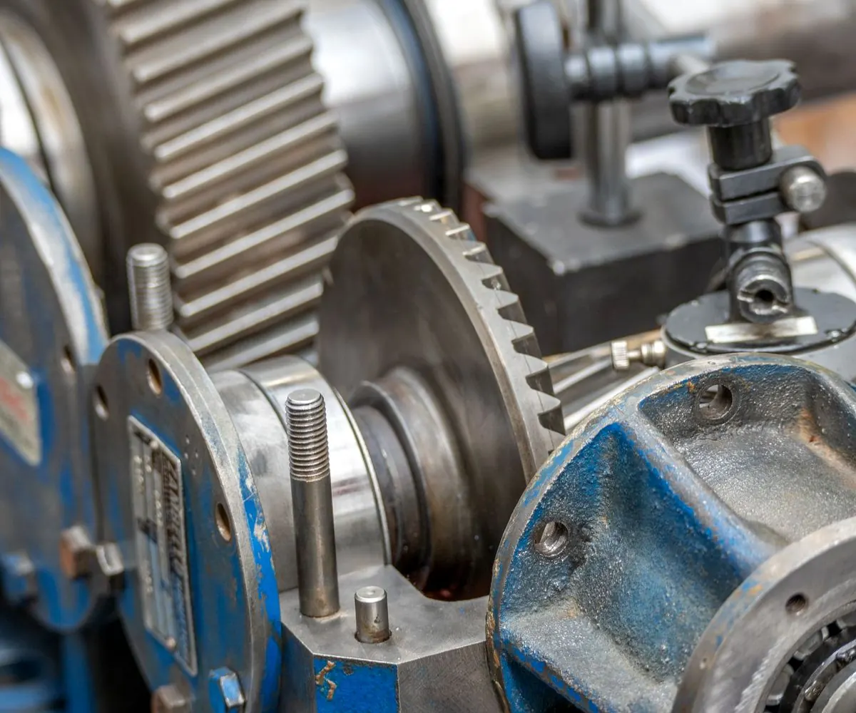 Meshed industrial gears in a machine housing.