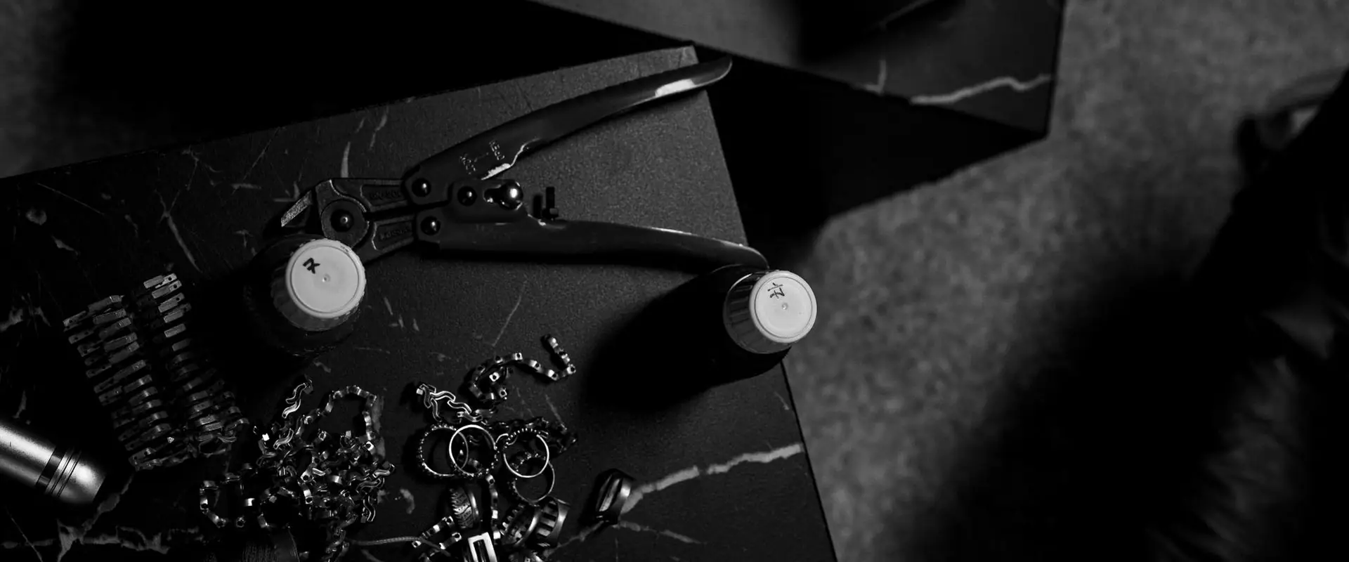 Callipers, gauges and small fixings laid out on a dark surface.