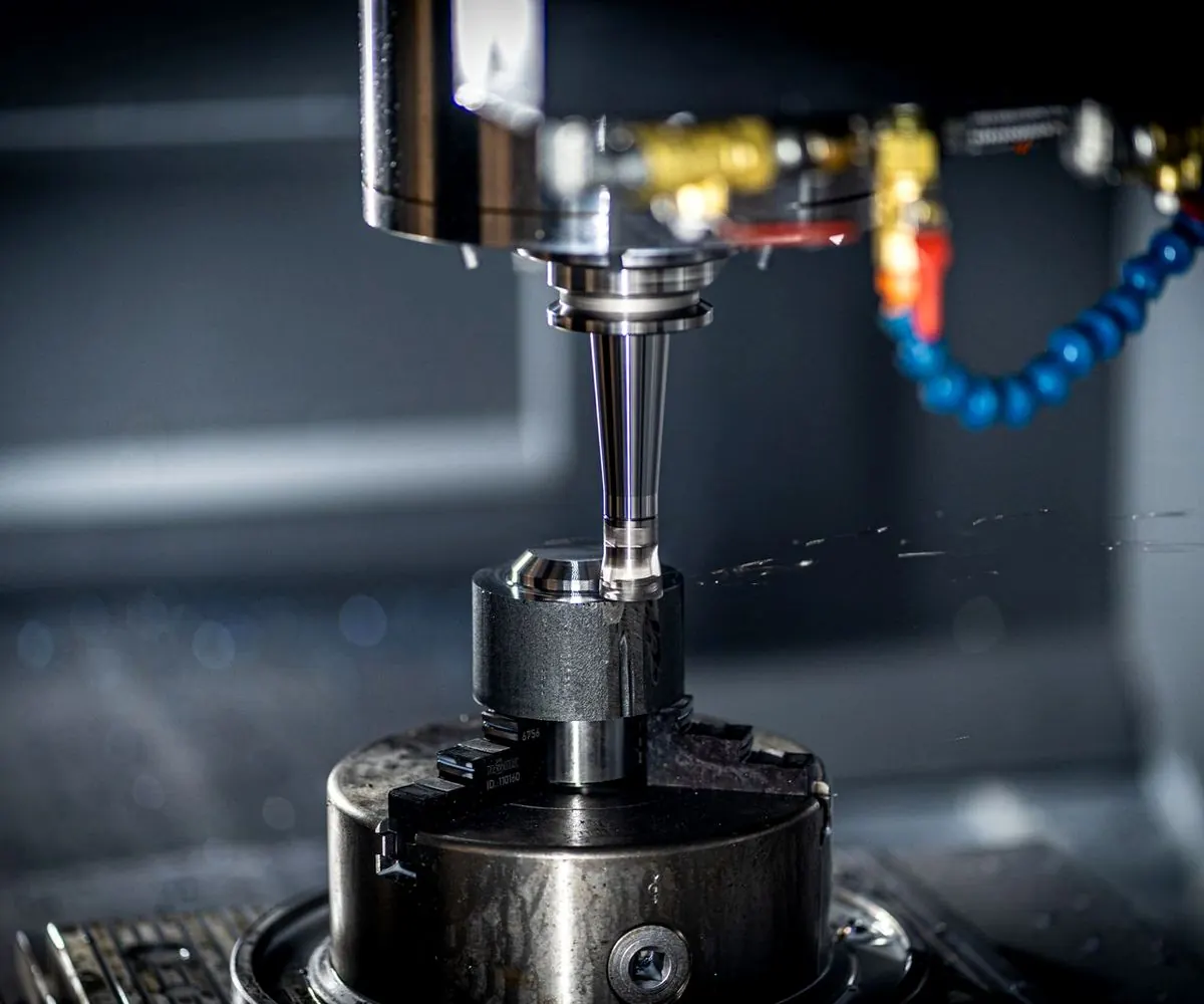 A CNC cutter working under coolant lines.